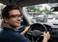 Homem dirige carro usando óculos inteligentes com navegação projetada no trânsito de São Paulo