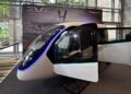 Cabine futurista do eVTOL Eve em exposição com iluminação azul neon, bancos internos e painel ao fundo do Brazil Investment Forum