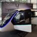 Cabine futurista do eVTOL Eve em exposição com iluminação azul neon, bancos internos e painel ao fundo do Brazil Investment Forum