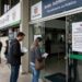 Cidadãos aguardam na porta do Detran-PR, que suspendeu temporariamente os agendamentos para exames de CNH.