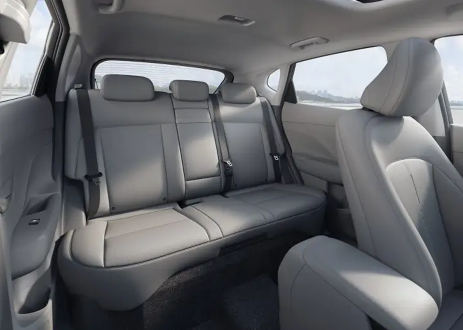 Interior do Hyundai Kona mostrando banco traseiro cinza claro com três lugares, encostos de cabeça e cintos de segurança