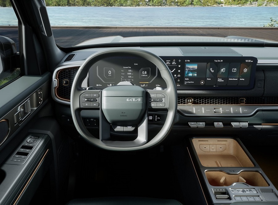 Cabine da Kia Tasman exibe volante com logo Kia, cluster digital de 12,3", tela multimídia e console com acabamento caramelo
