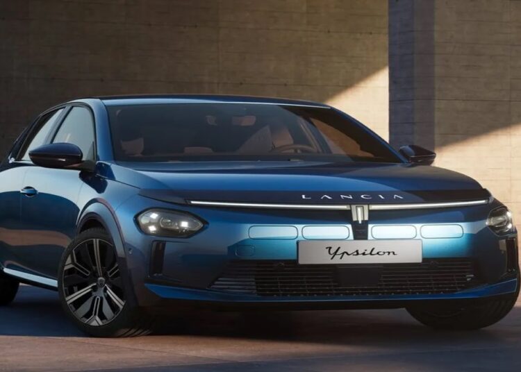Lancia Ypsilon elétrico na cor azul escura com detalhes em preto brilhante, faróis de LED acesos e logotipo no capô