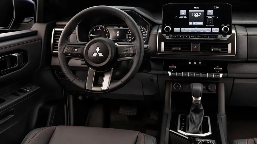 Painel da Triton com volante Mitsubishi, multimídia de 8 polegadas sintonizada em rádio FM e alavanca de câmbio automático