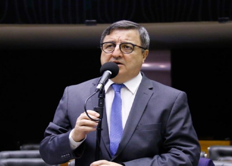 Deputado Danilo Forte ao microfone no plenário da Câmara, de terno cinza e gravata azul