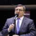 Deputado Danilo Forte ao microfone no plenário da Câmara, de terno cinza e gravata azul