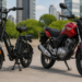 Bicicleta elétrica preta e moto vermelha flex lado a lado em ambiente urbano ensolarado
