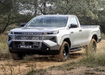 Toyota Hilux 2027 prata, cabine simples, em trilha de terra, novo visual e grade marcante