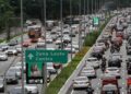 Congestionamento na Radial Leste com placa indicando Zona Leste e Centro, carros e ônibus em múltiplas faixas