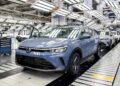 Nivus azul em destaque na linha de produção da Volkswagen, com outros veículos ao fundo sob iluminação industrial
