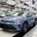 Nivus azul em destaque na linha de produção da Volkswagen, com outros veículos ao fundo sob iluminação industrial