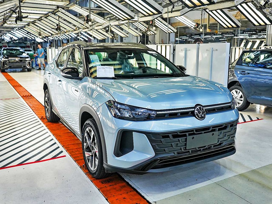 Nivus azul claro em linha de produção industrial da Volkswagen com esteiras e estruturas metálicas ao fundo
