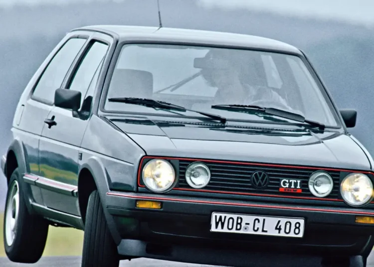 Golf GTI MK2 cinza com grade frontal vermelha, faróis duplos redondos e placa WOB-CL 408 em estrada