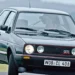 Golf GTI MK2 cinza com grade frontal vermelha, faróis duplos redondos e placa WOB-CL 408 em estrada