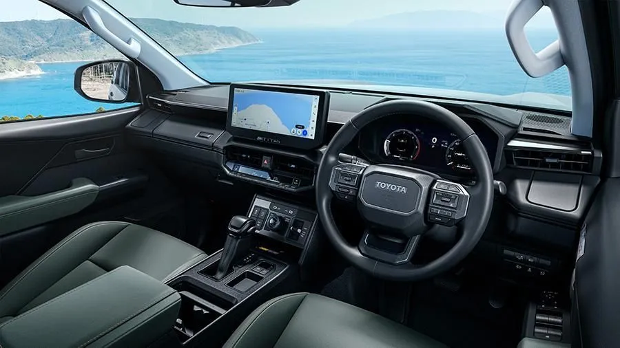 Painel moderno da Toyota Hilux 2027 com tela central exibindo navegação à beira-mar