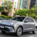 Carro elétrico GWM Ora 5 circulando por avenida urbana em 2026.