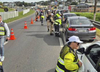 Blitz policial de trânsito na BR com abordagem a motoristas em operação conjunta.