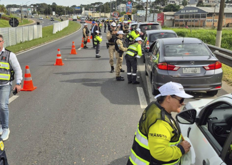 Blitz policial de trânsito na BR com abordagem a motoristas em operação conjunta.