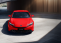 Honda Prelude vermelho de frente, destaque no capô e faróis, em ambiente urbano iluminado.