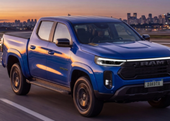 RAM Dakota azul circula em rodovia ao entardecer.