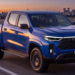 RAM Dakota azul circula em rodovia ao entardecer.