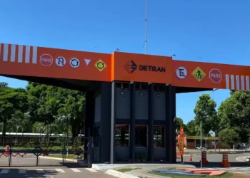Entrada da sede do Detran com placas de sinalização de trânsito.