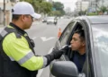 Agente de trânsito realiza teste do bafômetro em motorista durante fiscalização da Lei Seca.