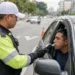 Agente de trânsito realiza teste do bafômetro em motorista durante fiscalização da Lei Seca.