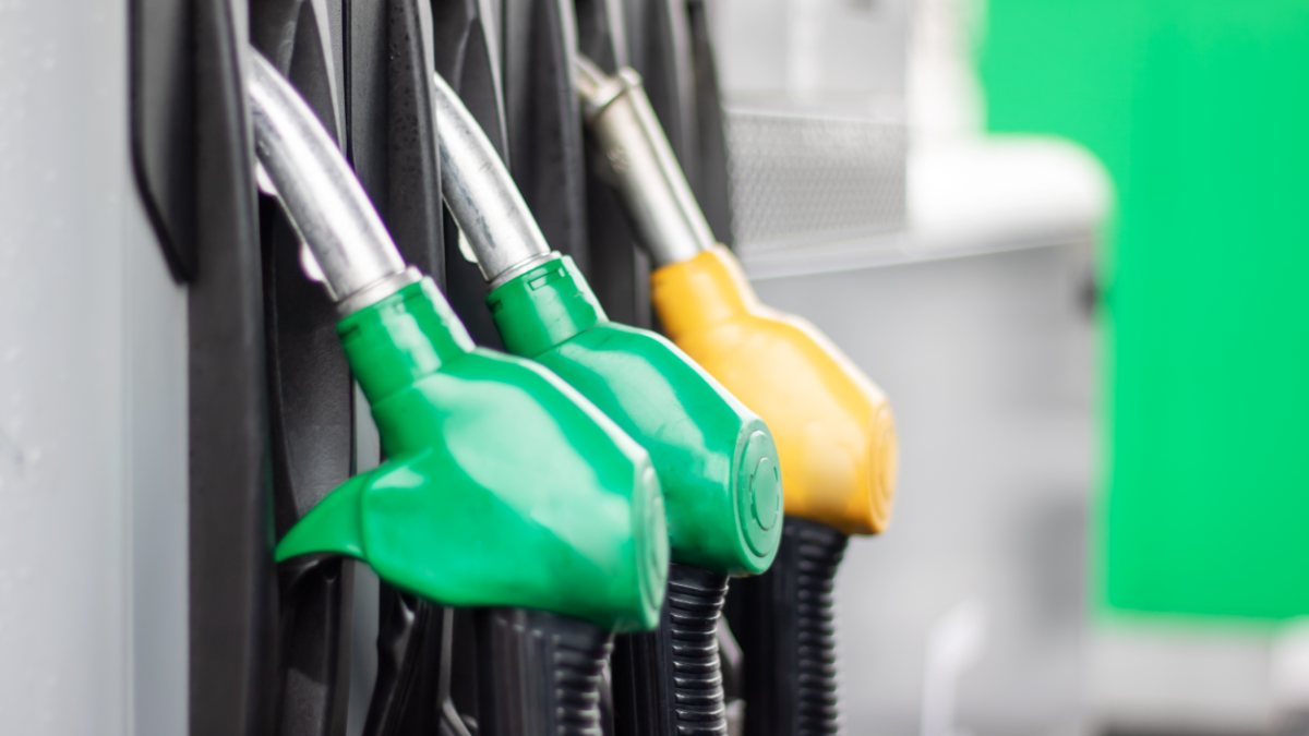 Bombas de combustível coloridas em posto de gasolina destacam opções de abastecimento.