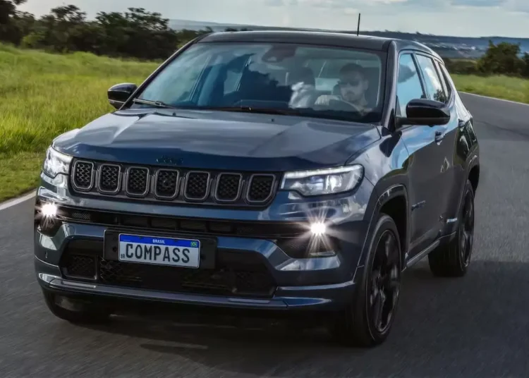 Jeep Compass 4xe híbrido plug-in em estrada com destaque para o sistema de recarga elétrica.