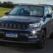Jeep Compass 4xe híbrido plug-in em estrada com destaque para o sistema de recarga elétrica.