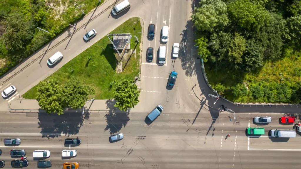 Trânsito em cruzamento urbano movimentado com fluxo intenso de carros.
