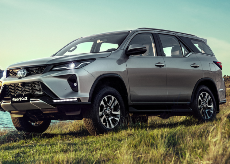 Toyota SW4 prata em destaque em paisagem natural ao pôr do sol.