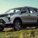 Toyota SW4 prata em destaque em paisagem natural ao pôr do sol.
