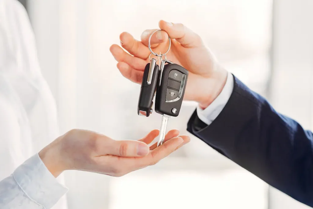 Entrega de chave de carro novo representando a definição de veículo 0 km pela legislação brasileira.