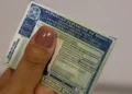 Carteira Nacional de Habilitação (CNH) brasileira segurada por uma pessoa, representando as regras de suspensão por pontos na carteira de motorista.