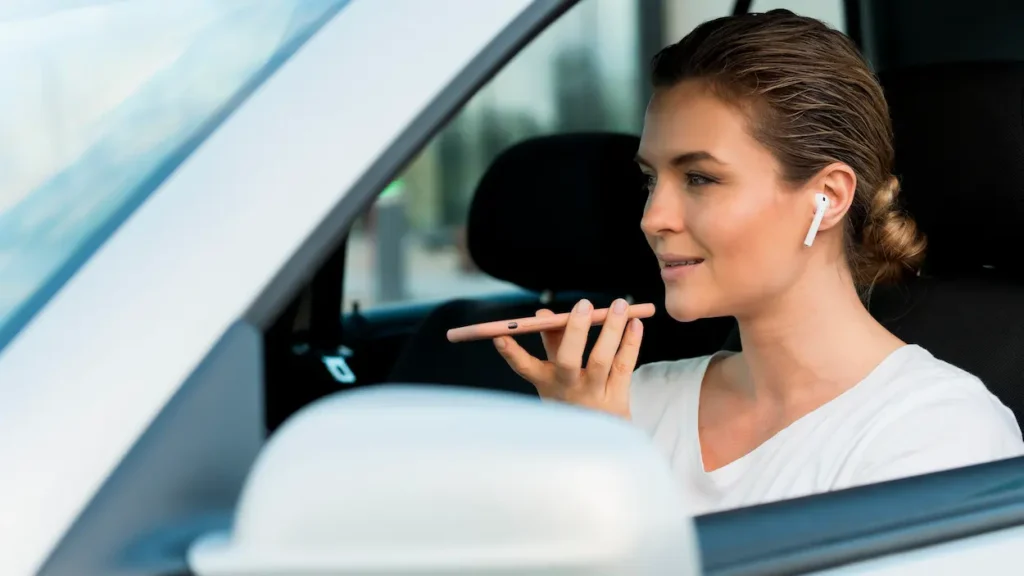 Motorista usa fone de ouvido e celular dentro do veículo, prática que pode reduzir a percepção dos sons do trânsito.