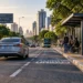 Carro circulando próximo ao ponto de ônibus em via urbana com sinalização de transporte coletivo.