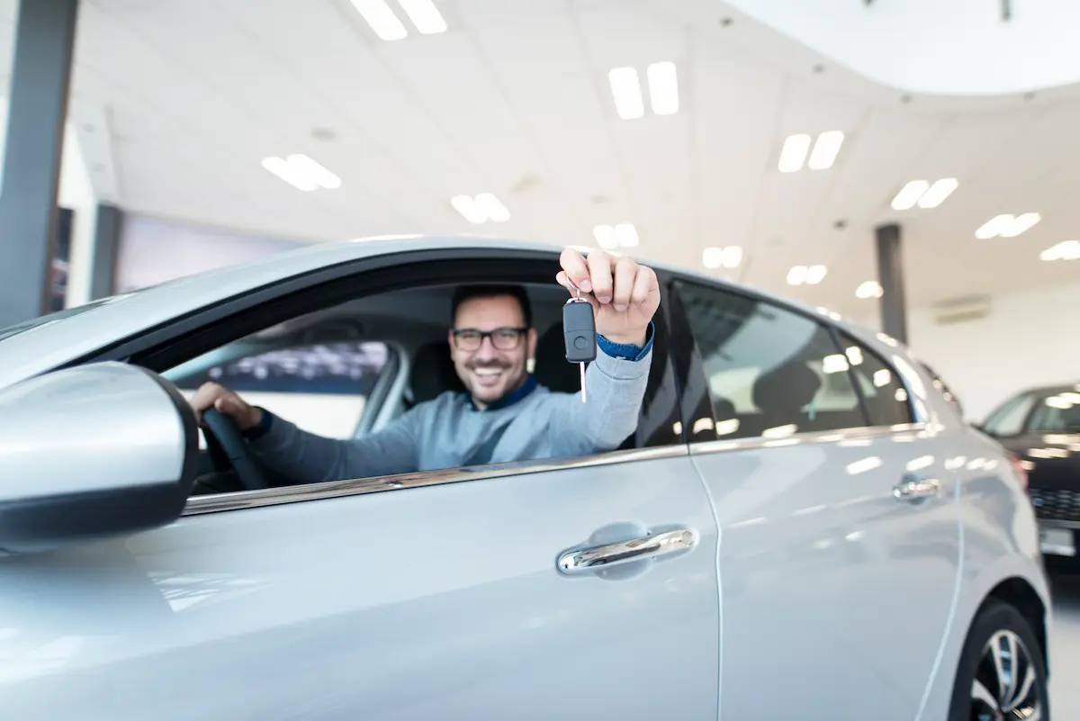 Motorista recebe chave de veículo representando aprovação de financiamento pelo programa Move Brasil.