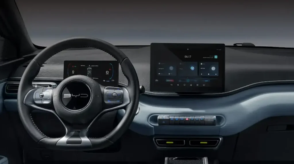 Interior do BYD Dolphin Mini destaca painel digital moderno e volante multifuncional.