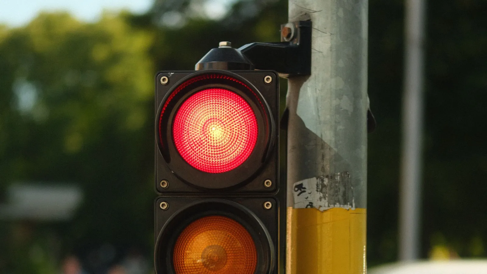 Semáforo de trânsito com a luz vermelha acesa em uma rua